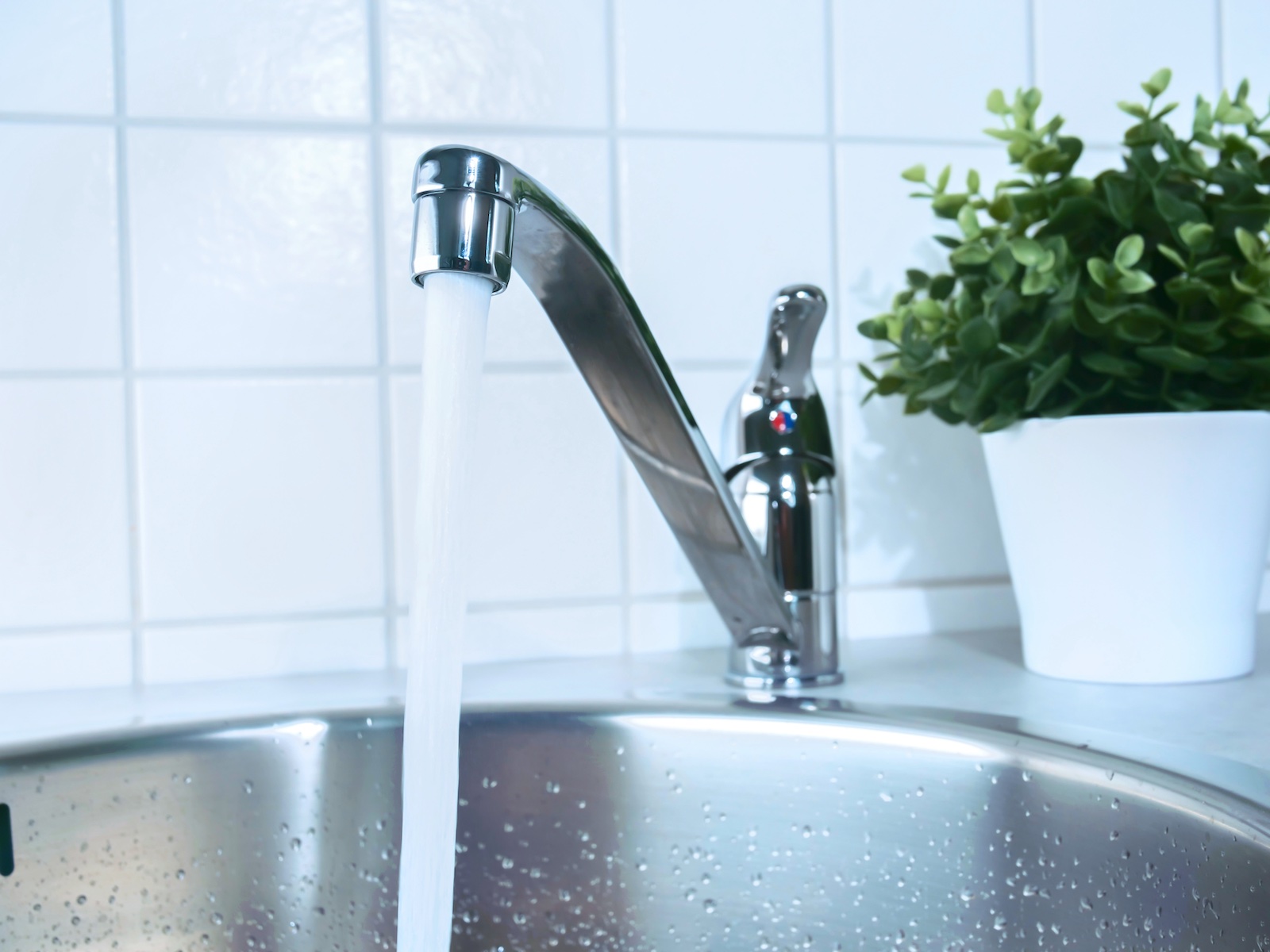 Ein laufender Wasserhahn in einer Küche.