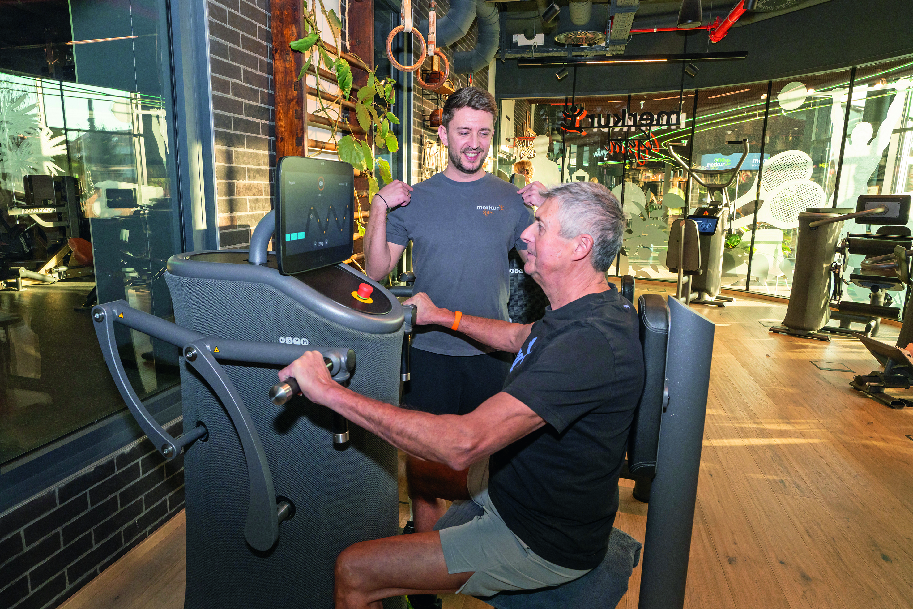 Mann sitzt an einem Fitnessgerät