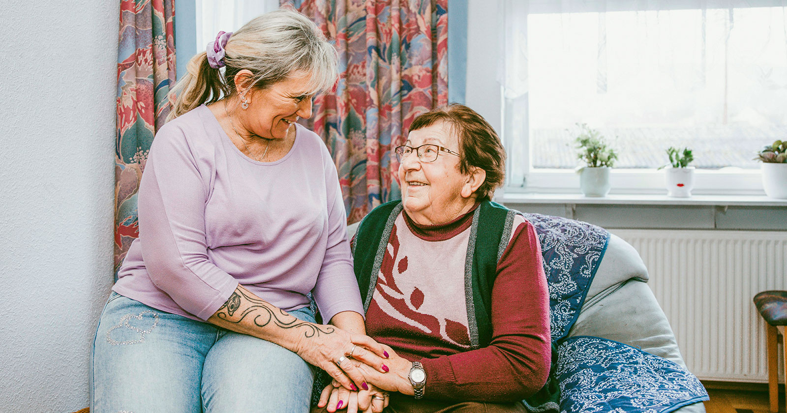 Weibliche Pflegekraft hält Seniorin die Hand | Credit: Diakoniewerk/Ness Rubey