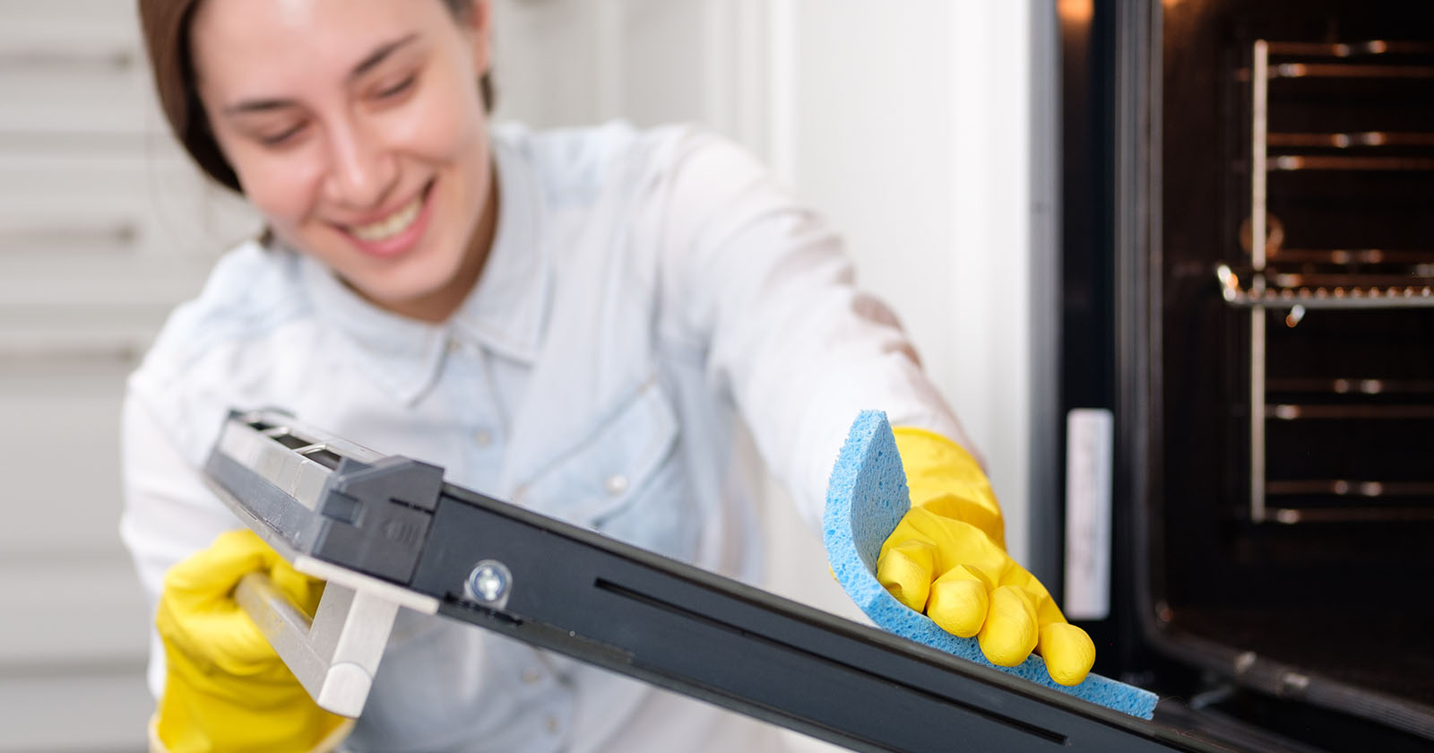 Frau reinigt Backofen | Credit: iStock.com/Alexander Medvedev