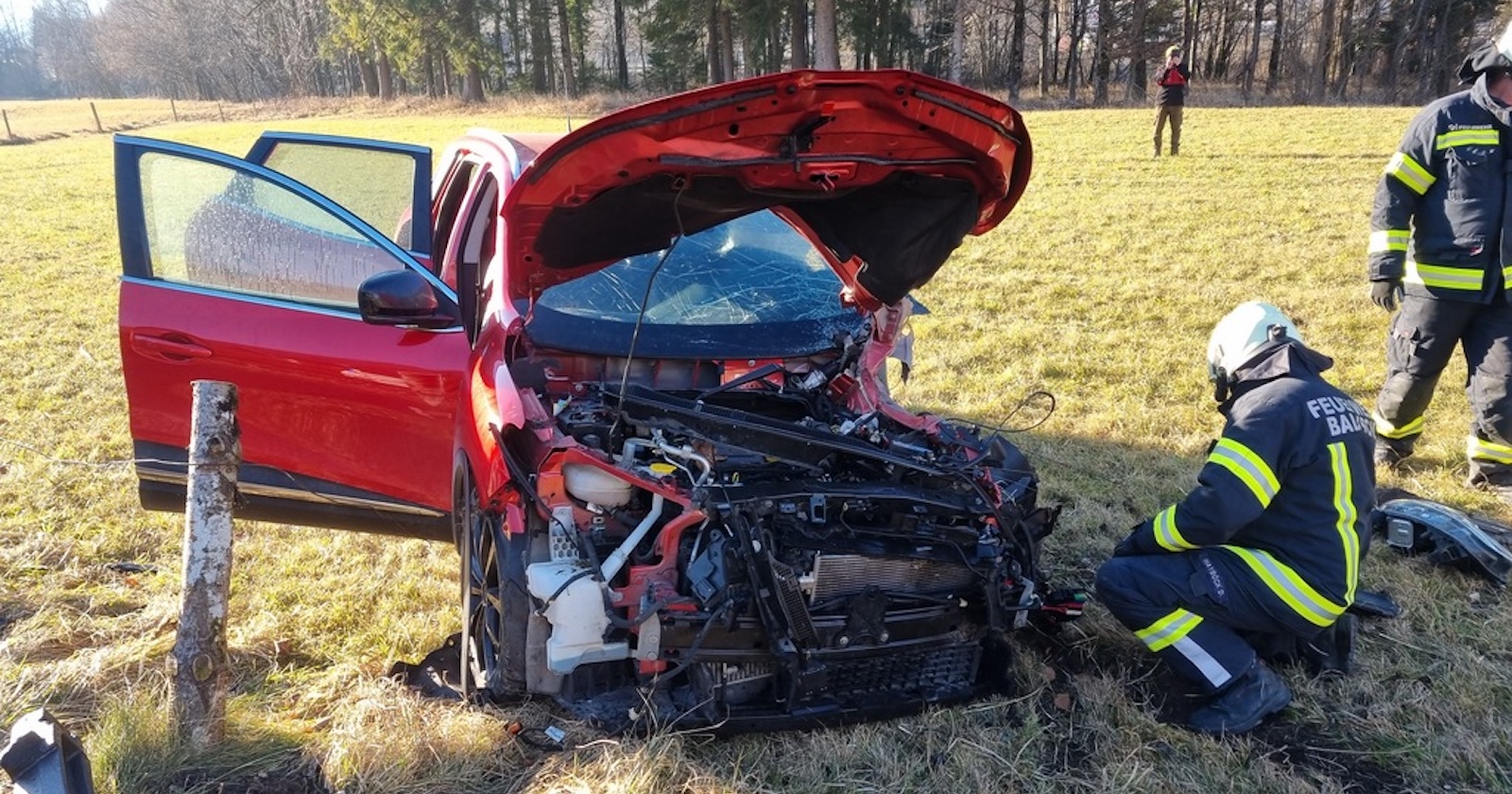 Das Wrack und zwei Feuerwehrleute.