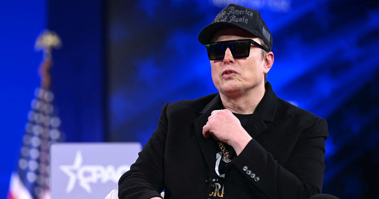 Mann sitzt mit Sonnenbrille auf einem Sessel