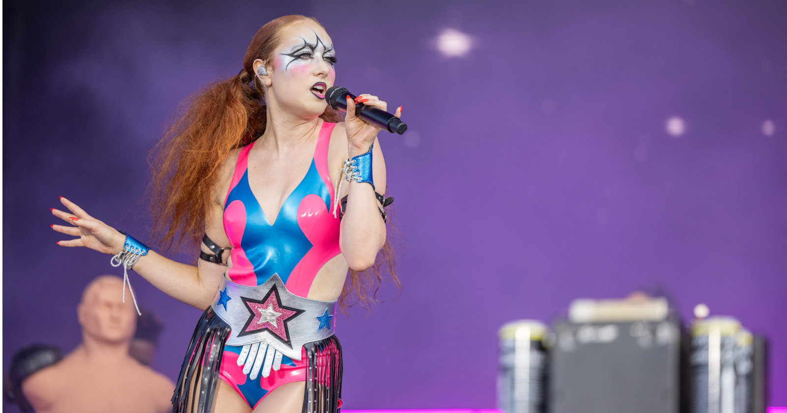 Bunt geschminkte Sängerin singt ins Mikrofon