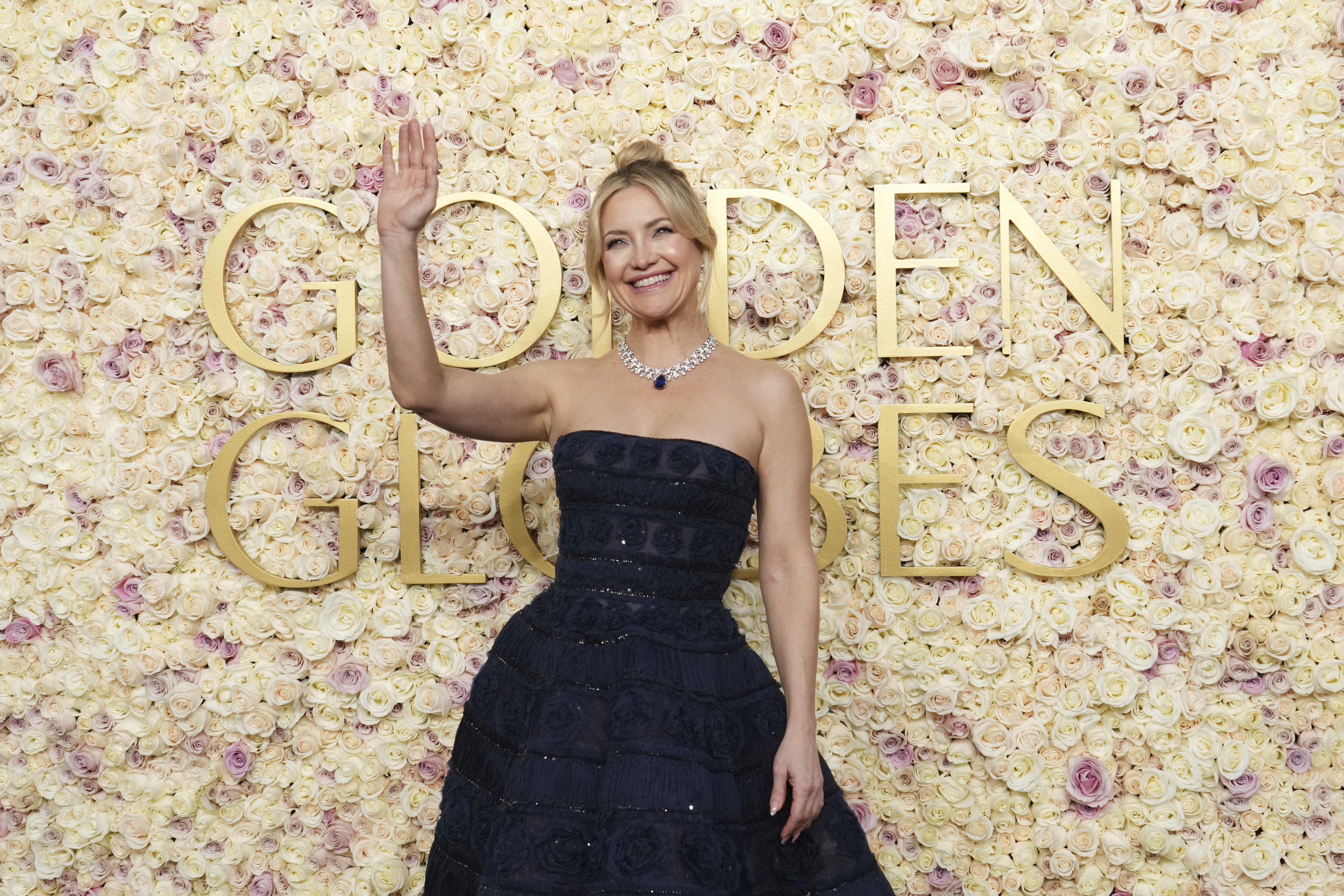 Frau in Robe winkt in die Menge