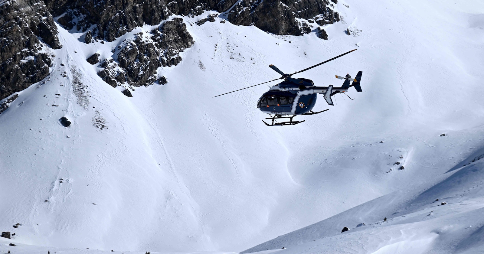 Ein Hubschrauber im Einsatz in einem Skigebiet.
