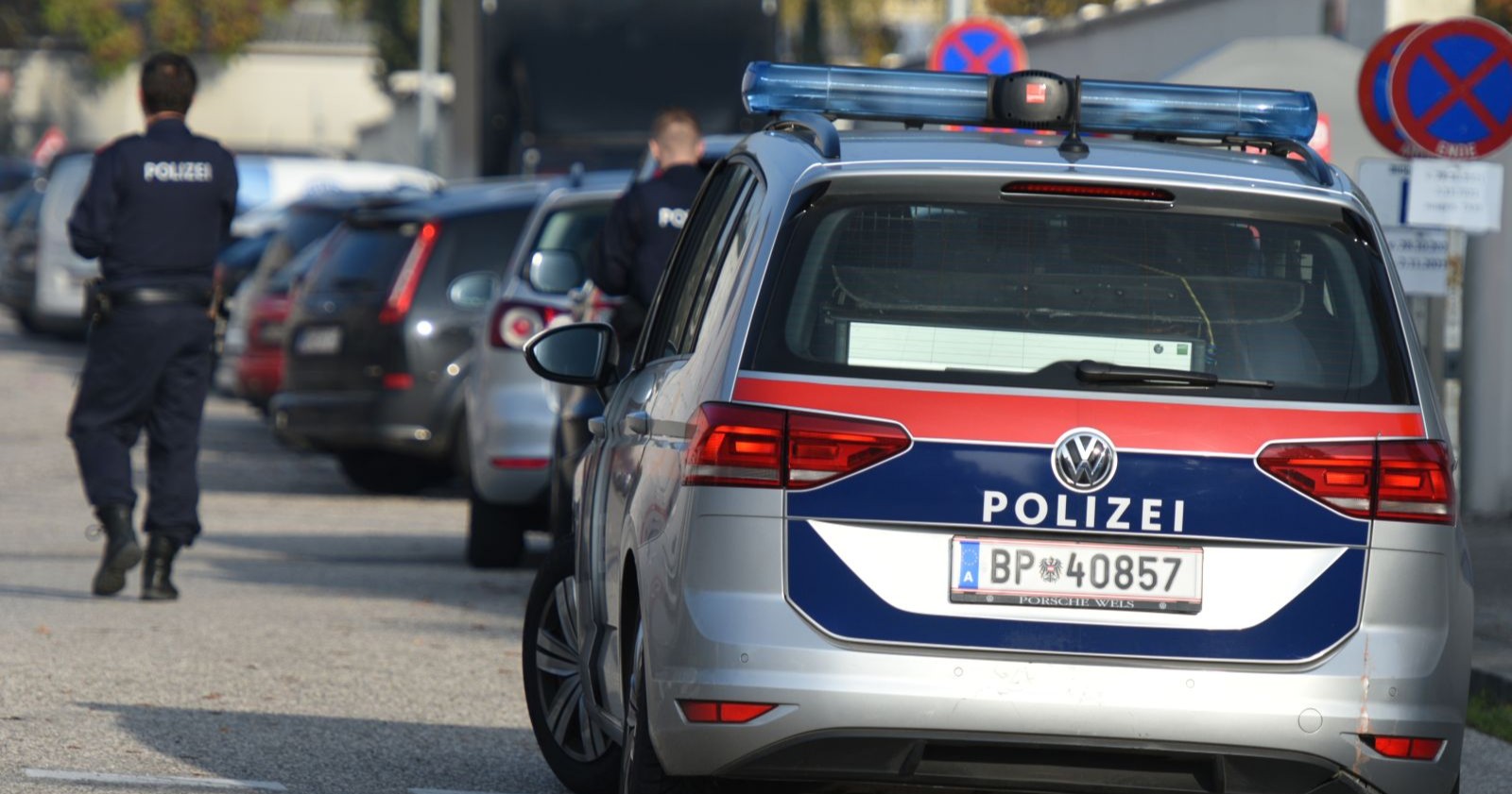 Polizist neben Polizeiwagen