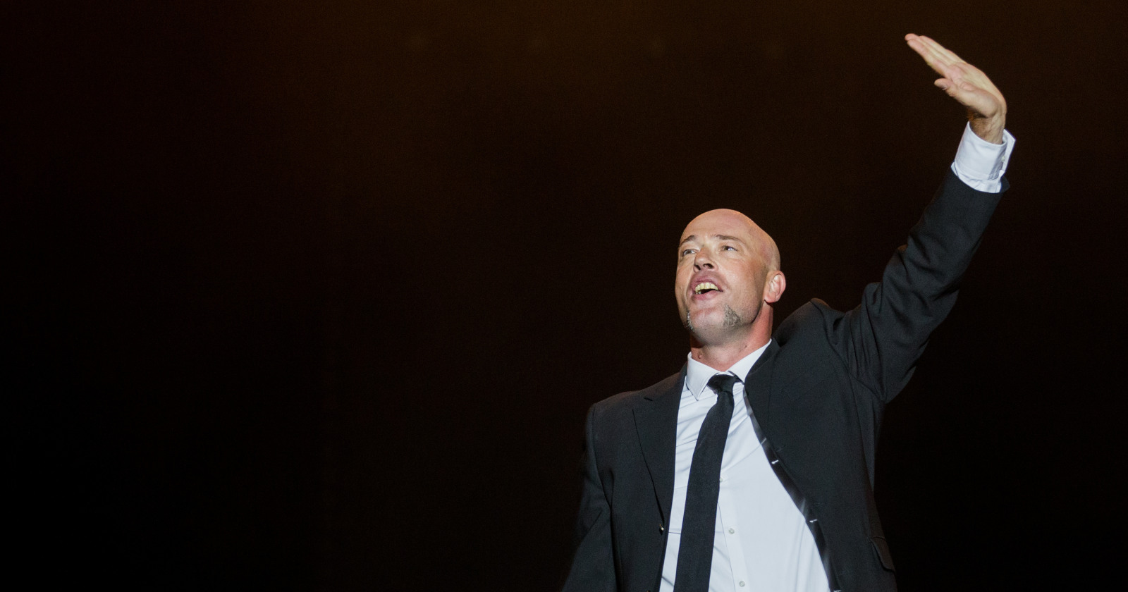 Mann in Anzug winkt in die Menge