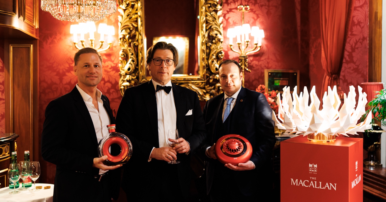 Drei Herren im Anzug halten im Restaurant &quot;Rote Bar&quot; des Hotel Sacher die neuen Whisky-Kreationen in ihren Händen
