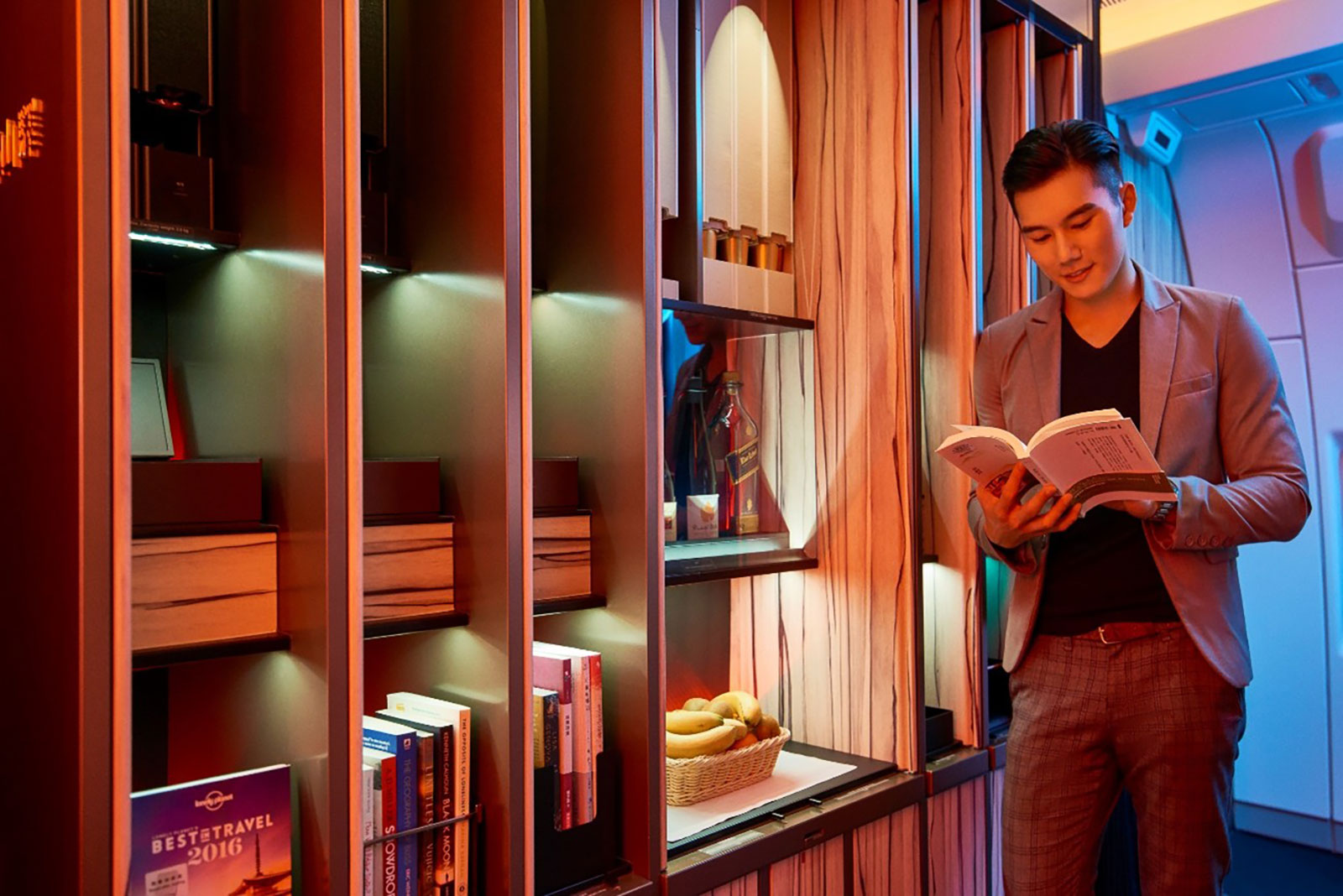 Junger Mann beim Lesen in einem Buch in der Lounge eines Flugzeuges | Credit: China Airlines