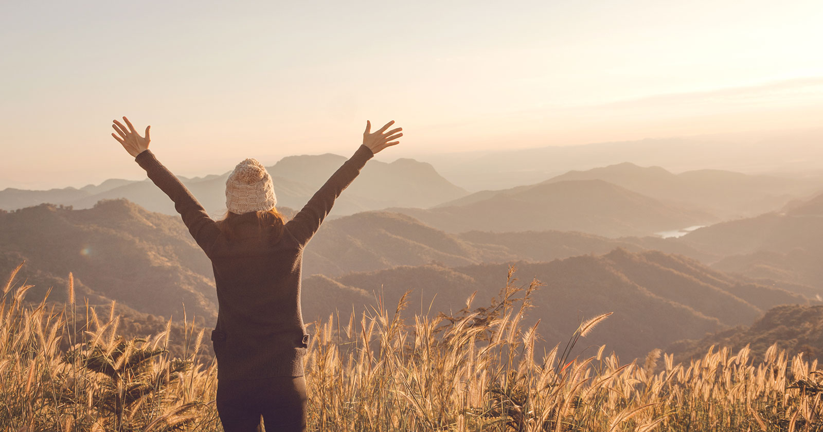 Frau beim Wandern im Sonnenaufgang | Credit: iStock.com/oatawa