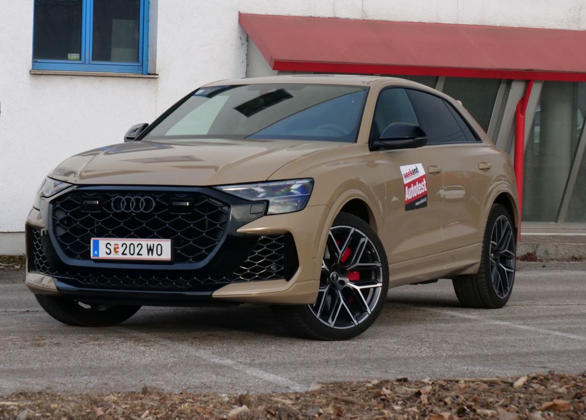 Ein kaffeebrauner  steht auf einem asphaltierten Parkplatz.