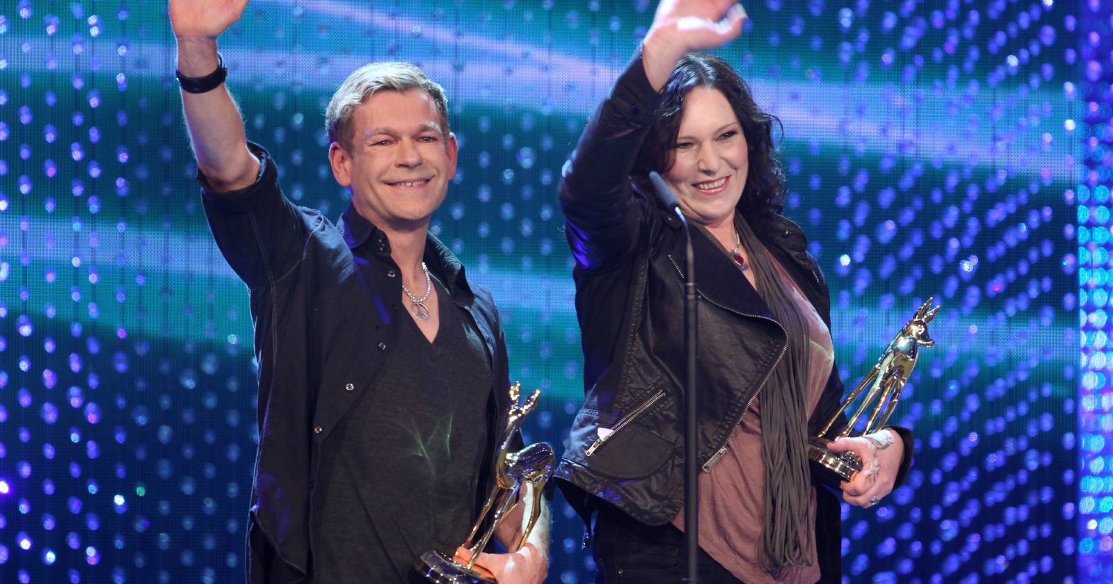 Anna R. und Peter Plate des Pop-Duos Rosenstolz winken auf der Bühne der Bambi-Preisverleihung dem Publikum zu und halten je eine goldene Bambi-Statuette in Händen