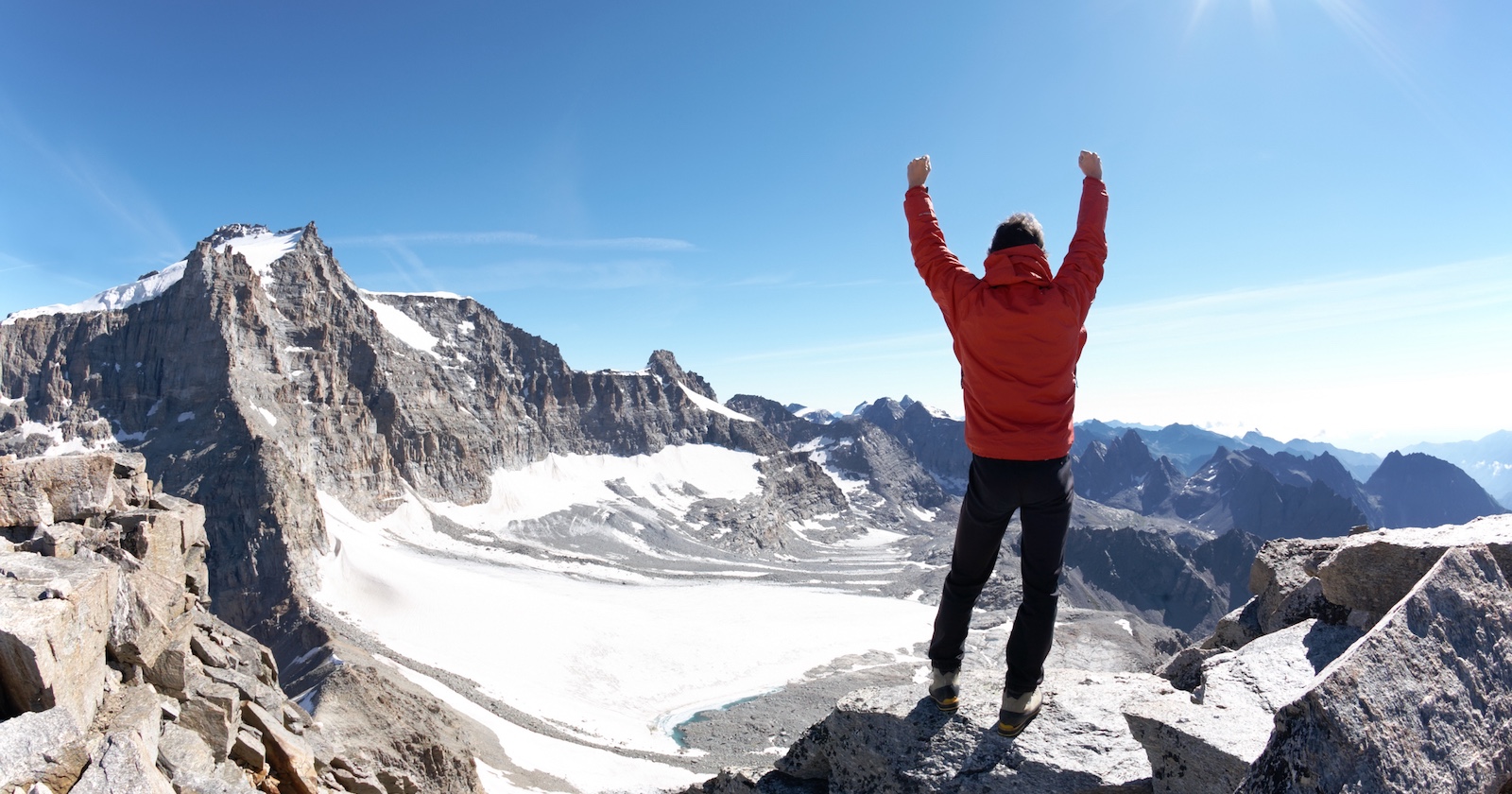 Junger Bergsteiger freut sich über den Erfolg, am Gipfel angekommen zu sein