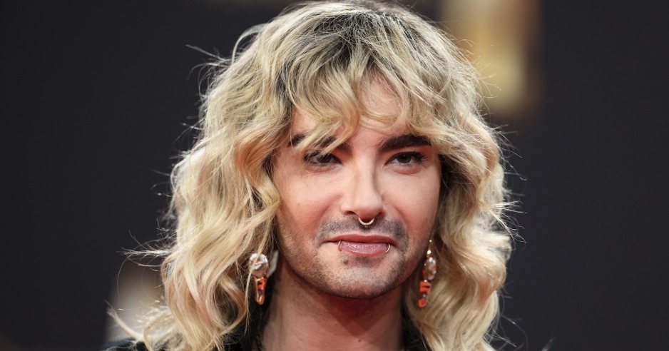 Bill Kaulitz mit blonden gewellten Haaren und Piercings im Gesicht.