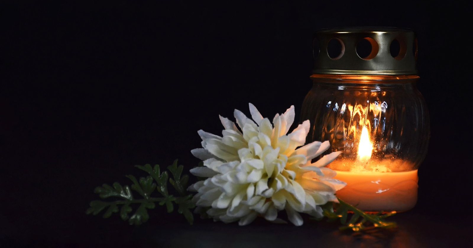 Blumen und eine Grabkerze