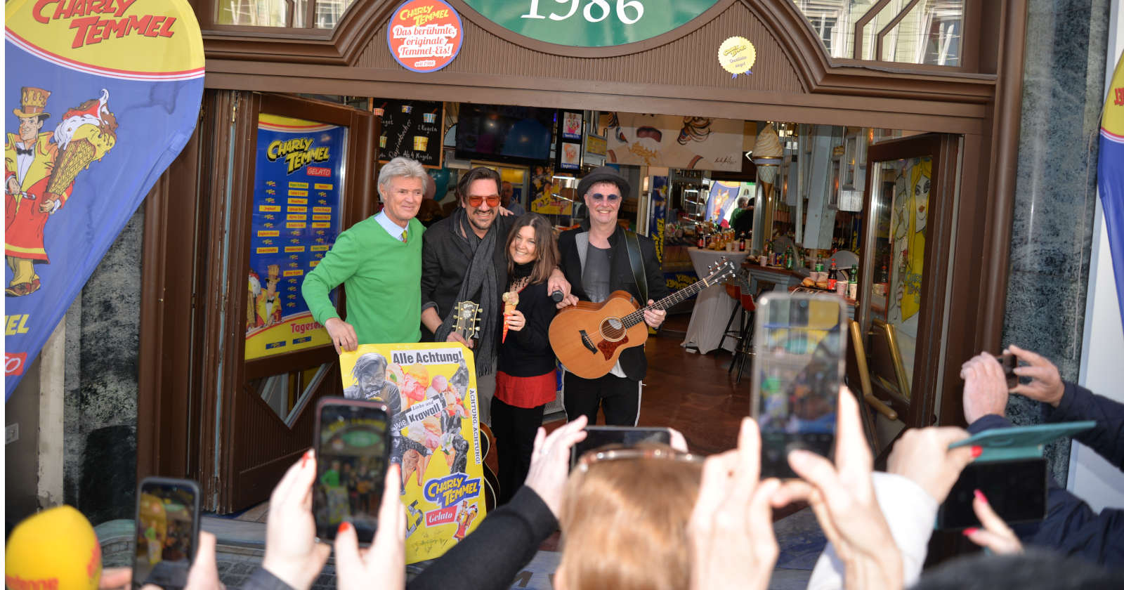 Mehrere Menschen posieren vor einem Eissalon für ein Foto