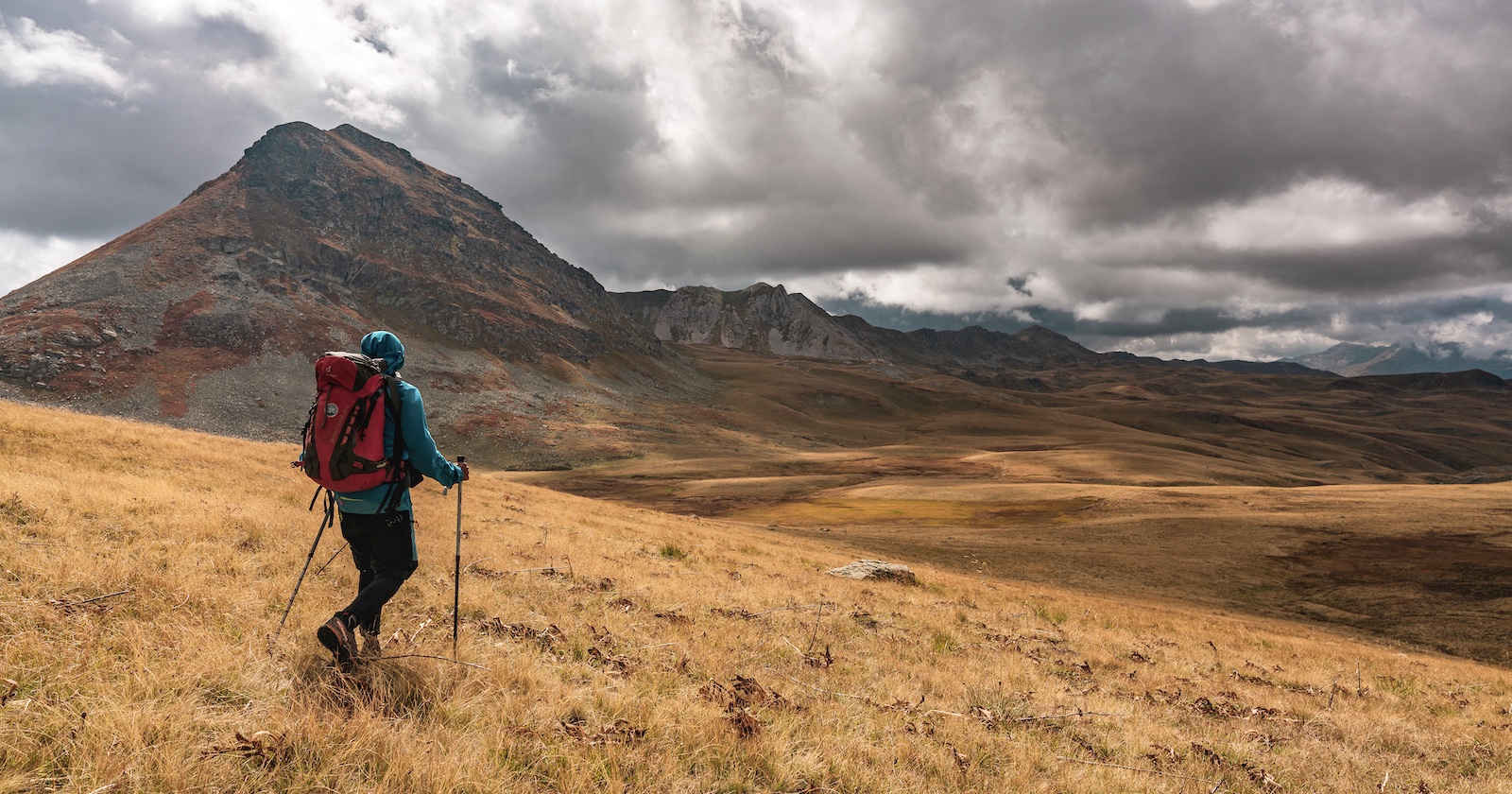 einsamer Wanderer in trockener Graslandschaft eines Hochplateaus