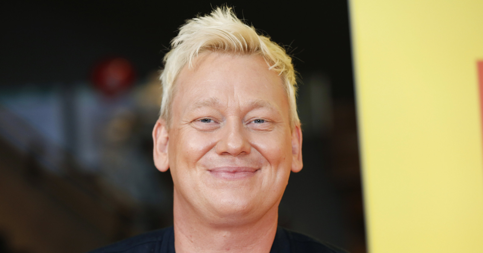 Blonder Mann lacht in die Kamera