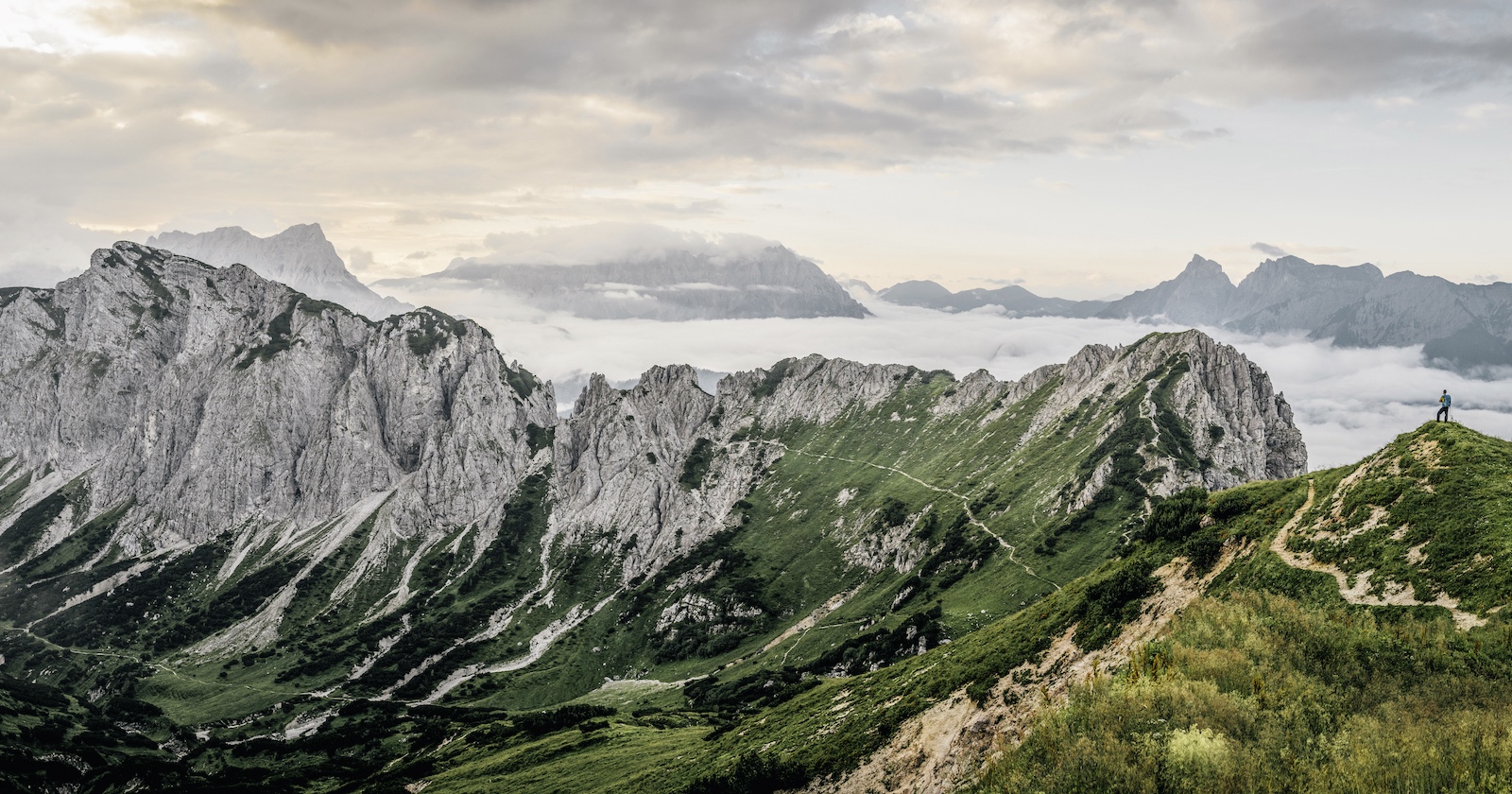 Bergpanorama mit einsamen Wanderer auf einem Alpinpfad