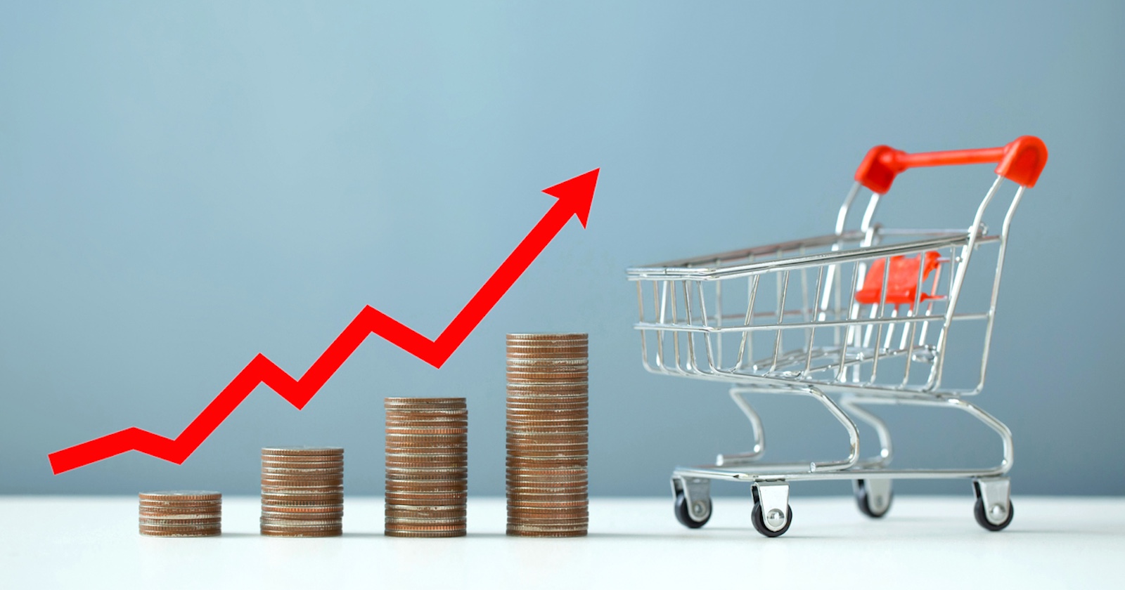 Münzen, Einkaufswagen und ein roter Pfeil steil nach oben.