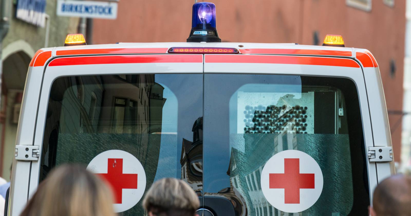 Nahaufnahme des Hecks eines Einsatzfahrzeuges des Roten Kreuzes mit Blaulicht