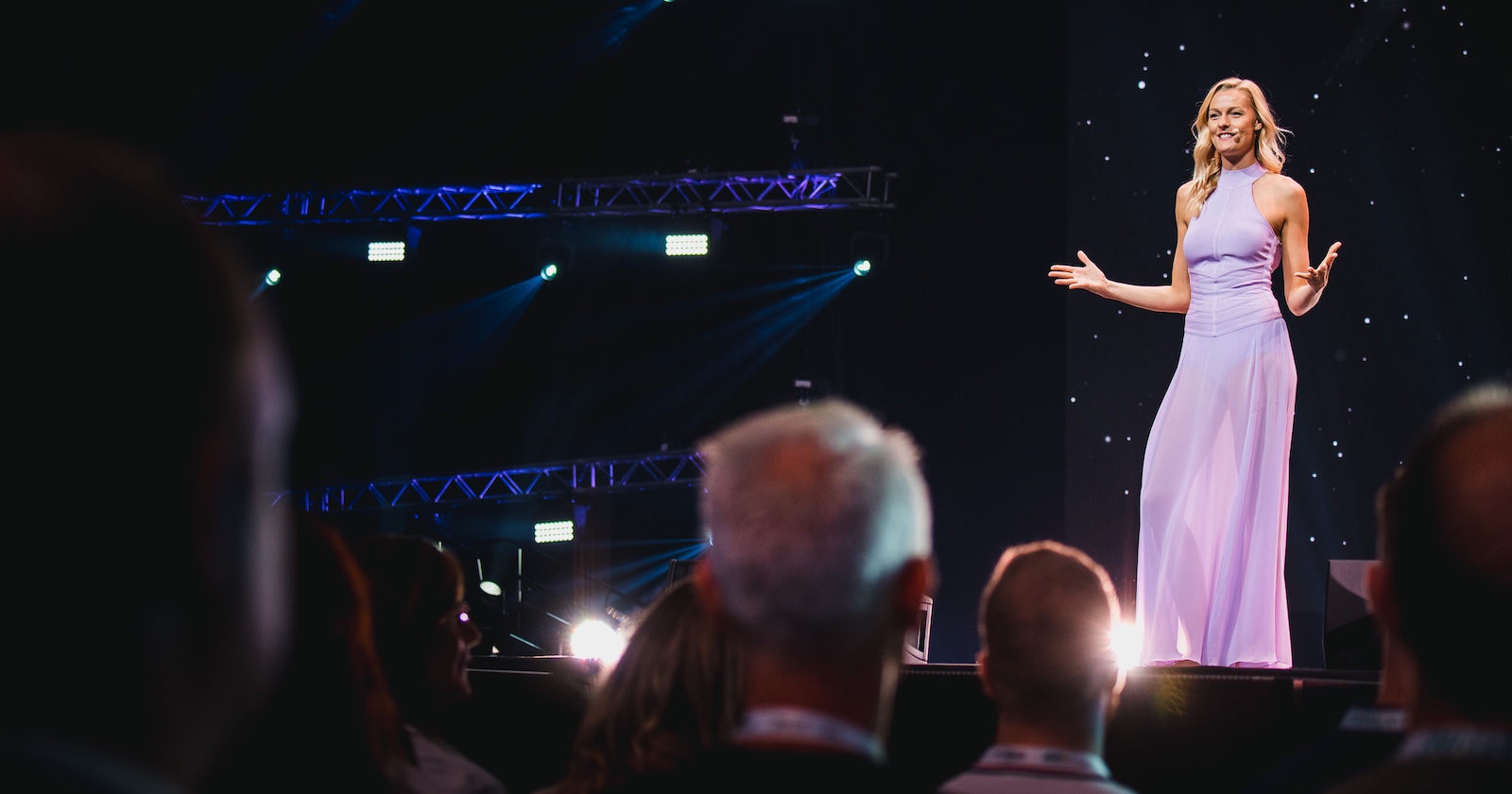 Miriam Höller steht in einem lila Kleid auf der Bühne.