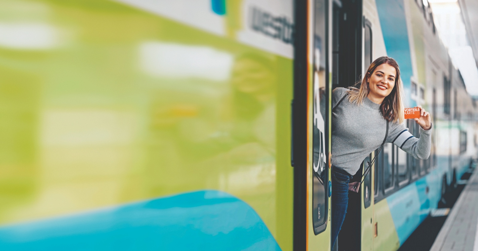 Frau steht in der Tür eines abfahrbereiten Zuges