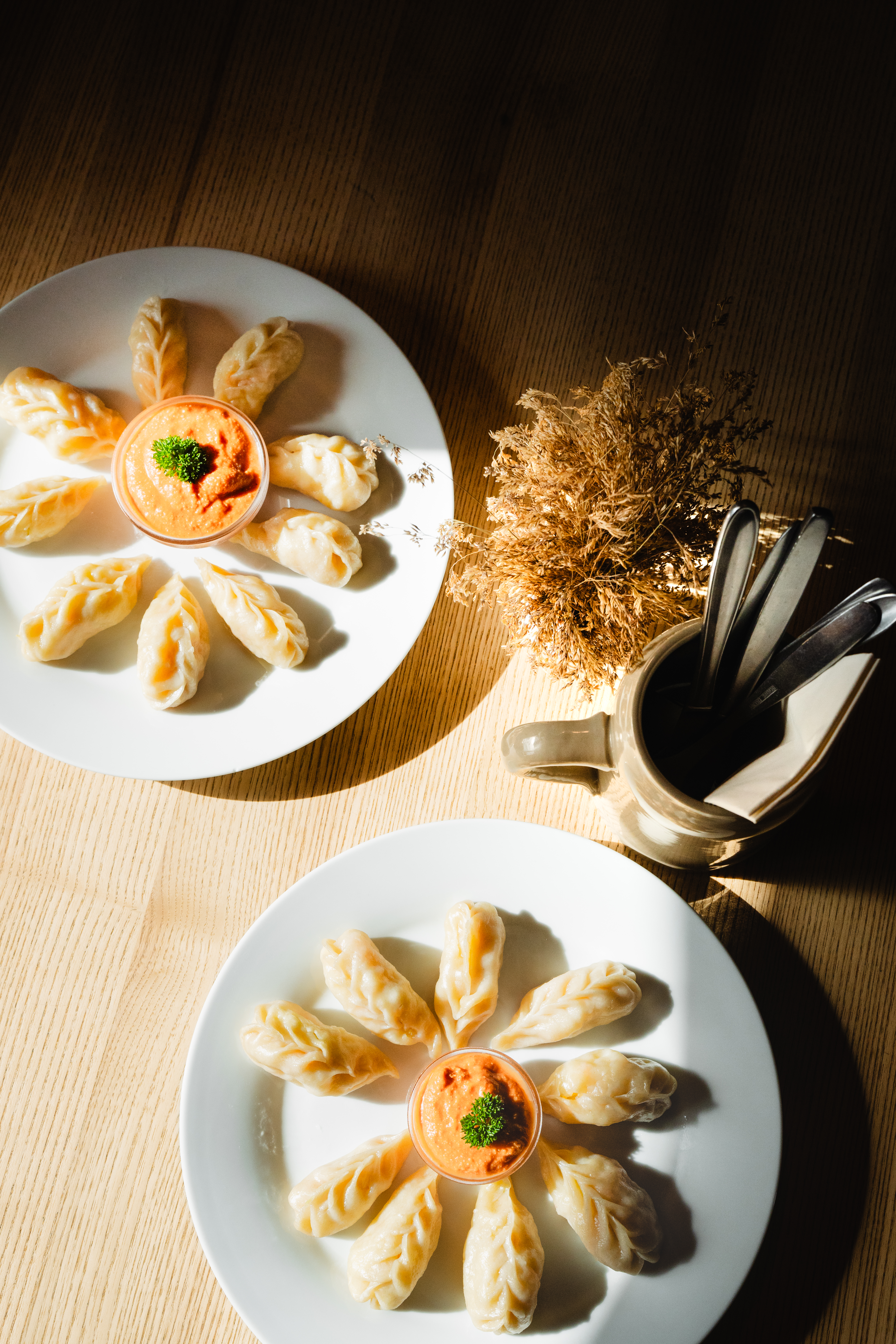 Mehrere Teigtaschen liegen auf zwei weißen Tellern