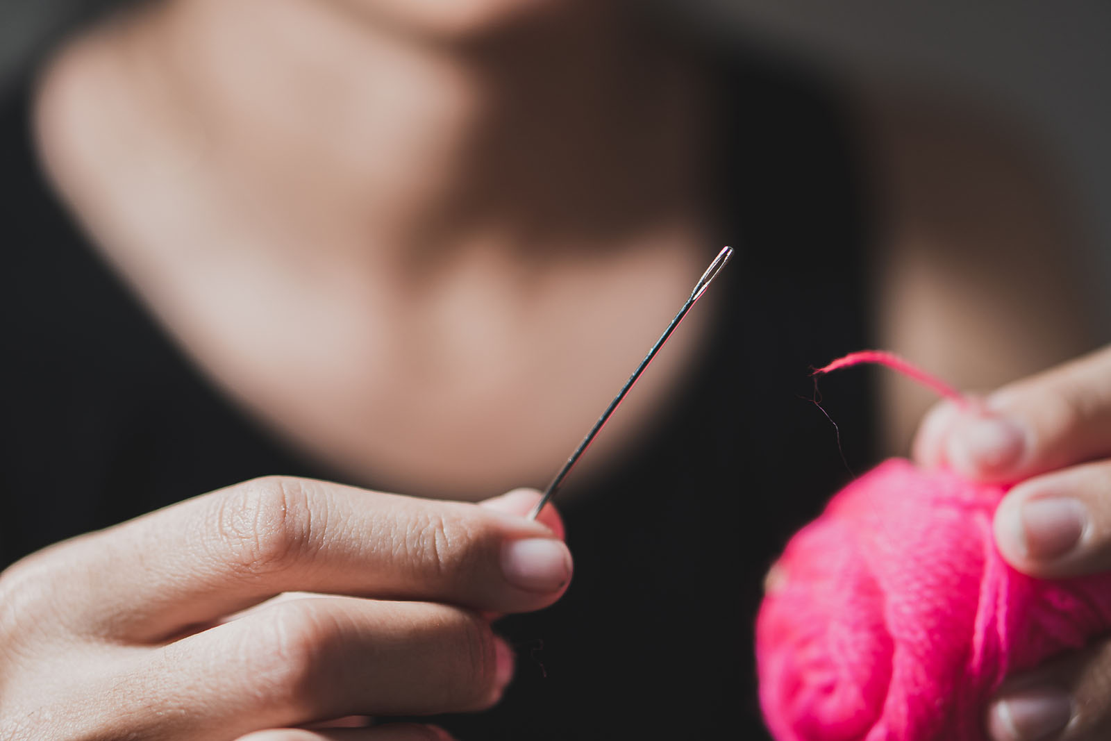 Frau fädelt Faden in Nadel ein | Credit: iStock.com/da bali