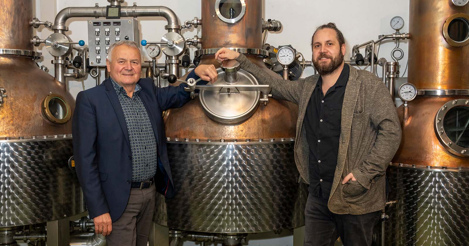 Alois und David Gölles vor einem Brennkessel in ihrer Destillerie