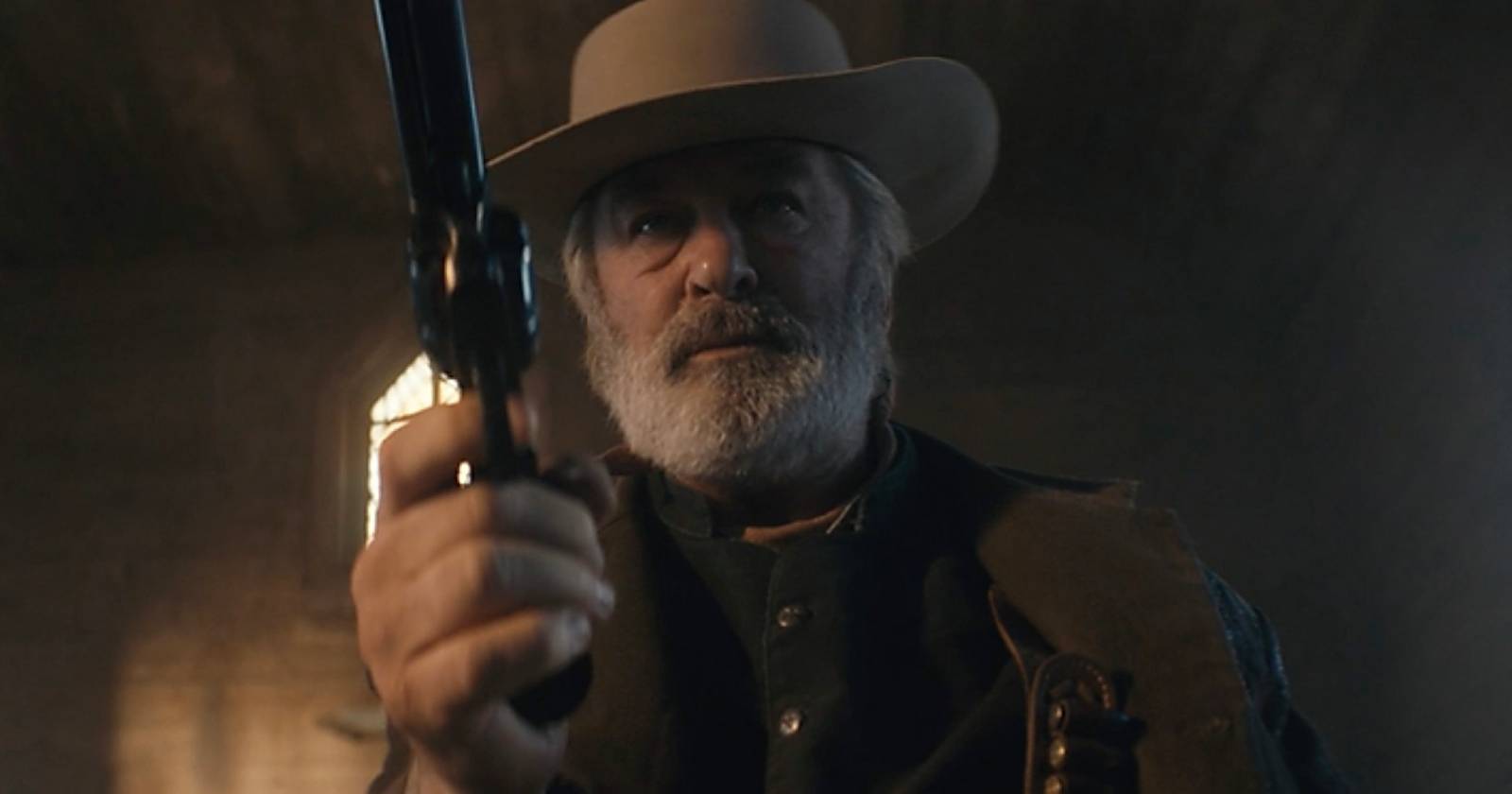 Szene aus dem Western &quot;Rust&quot;, die Alec Baldwin zeigt, der einen Cowboy-Hut trägt und mit einem Revolver auf die Kamera zielt