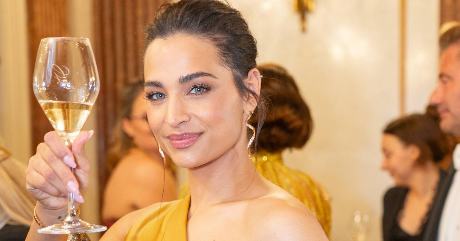 Amira Aly mit einem Sektglas in der Hand