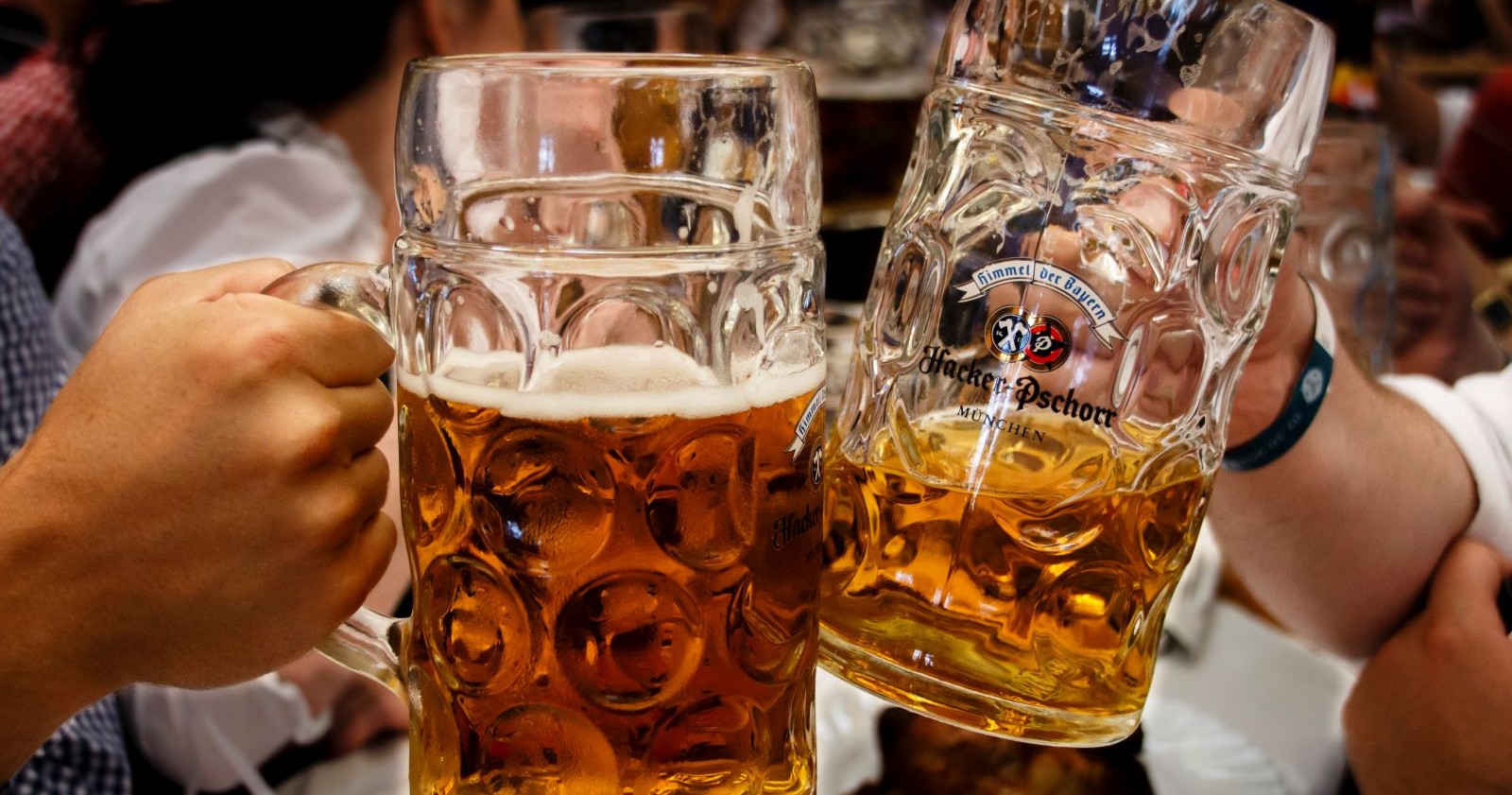 Zwei Menschen prosten mit einem Bierkrug.