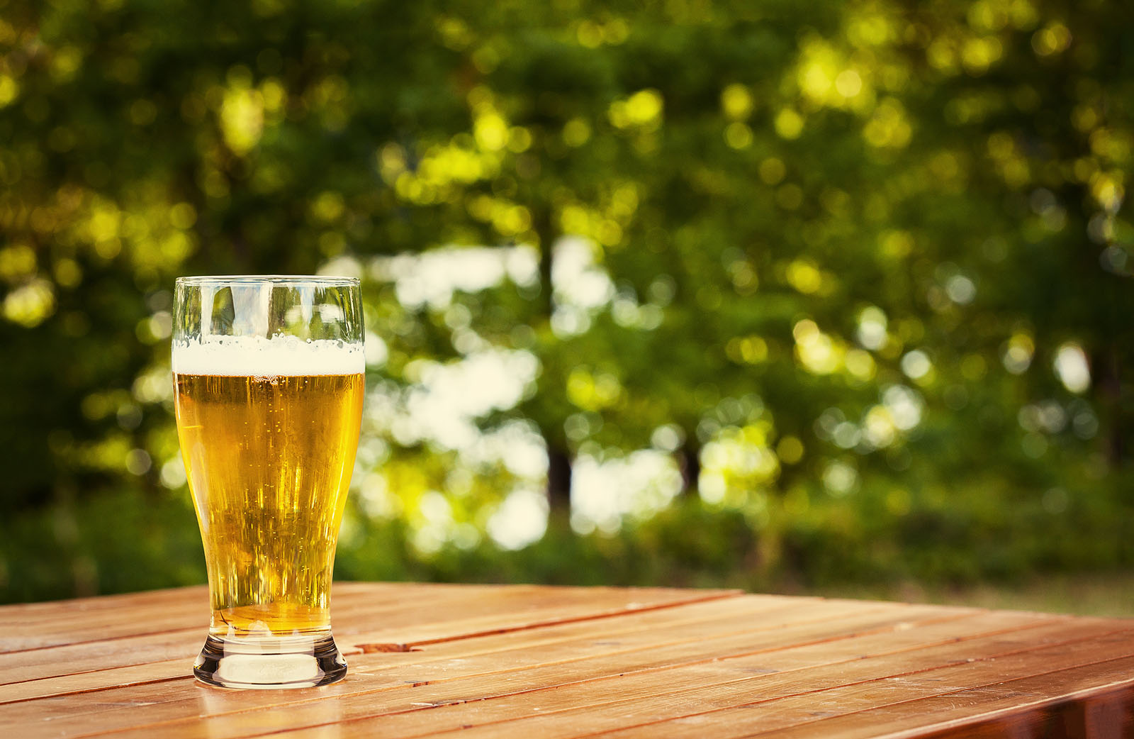 Ein Glas Bier auf einem Holztisch | Credit: iStock.com/Sociologas
