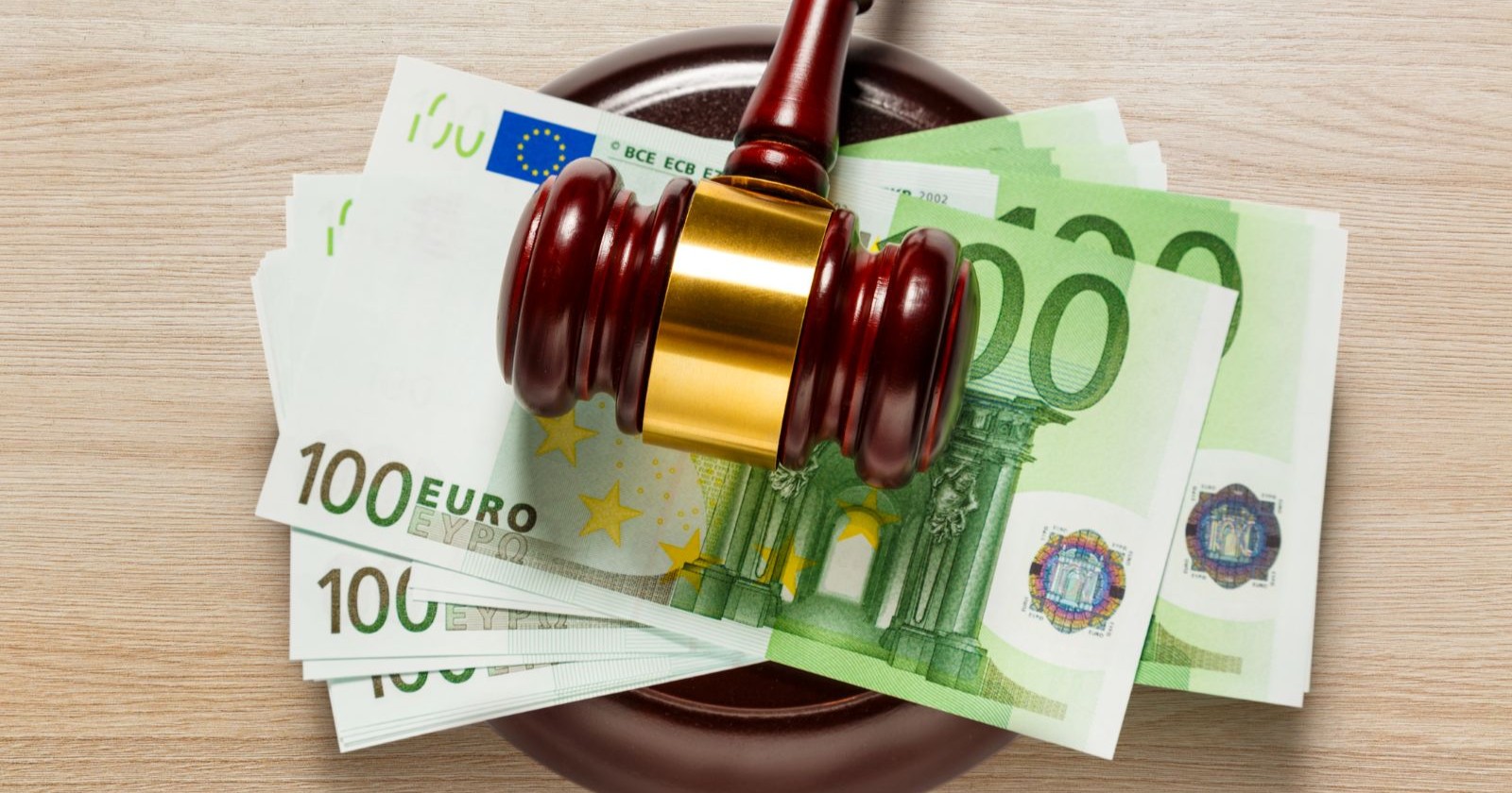 Hundert Euro Banknoten unter einem Hammer