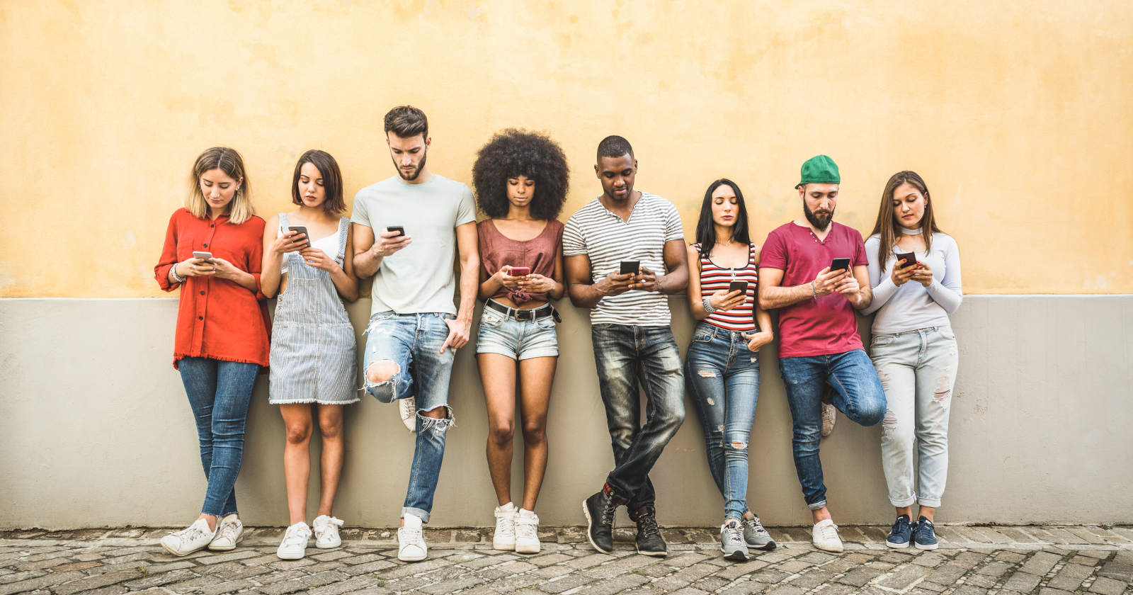 Mehrere Jugendliche starren auf ihr Handy