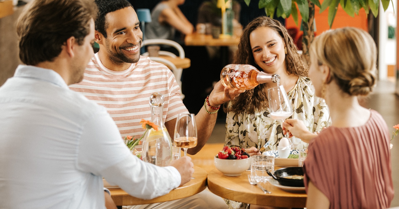Mann schenkt einer Frau ein Glas Sekt ein
