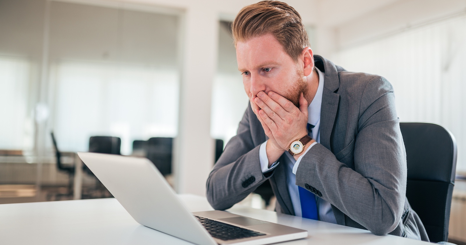 Mann hält sich erschrocken Hände vors Gesicht