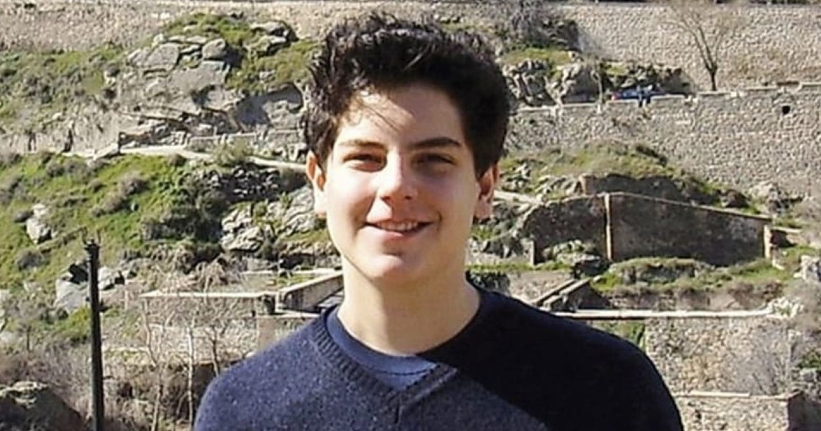 Carlo Acutis lächelt in einem blauen Pullover