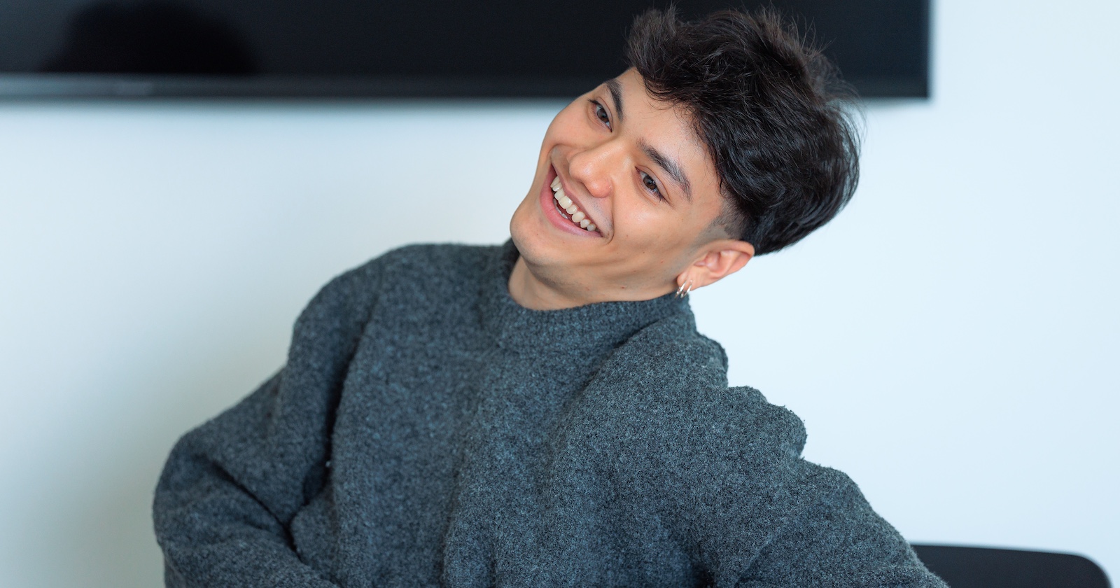 Sänger JJ im grauen Pullover hält kokett den Kopf zur Seite