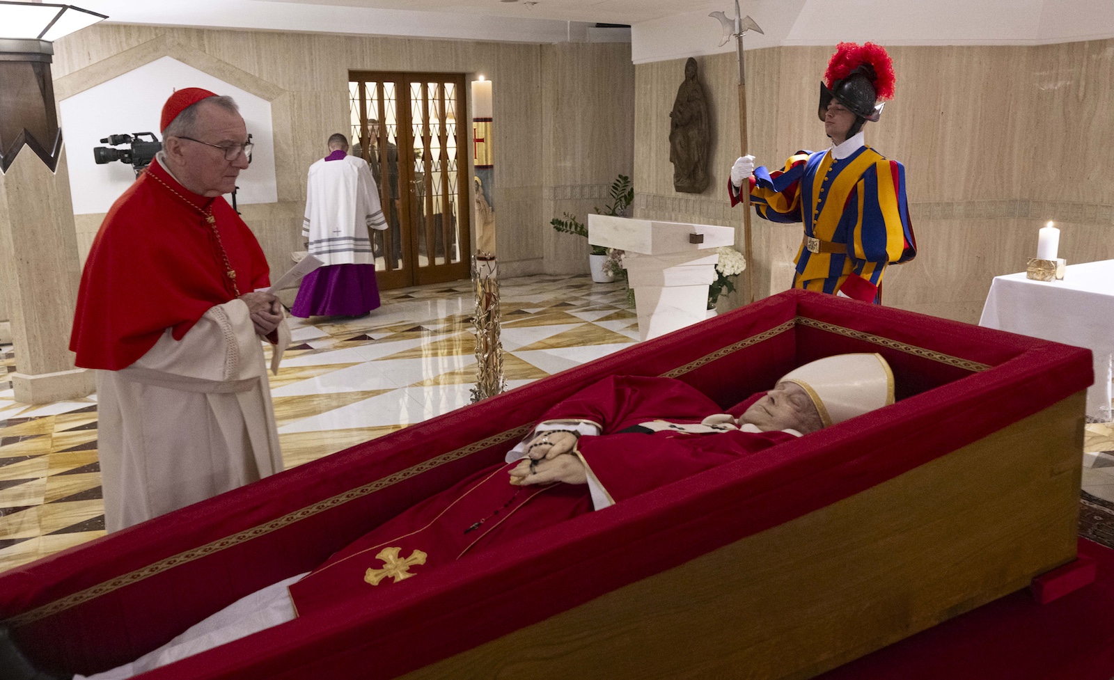 Papst Franziskus im offenen Sarg in der Kapelle der Residenz Santa Marta, daneben ein Kardinal und ein Mitglied der Schweizergarde