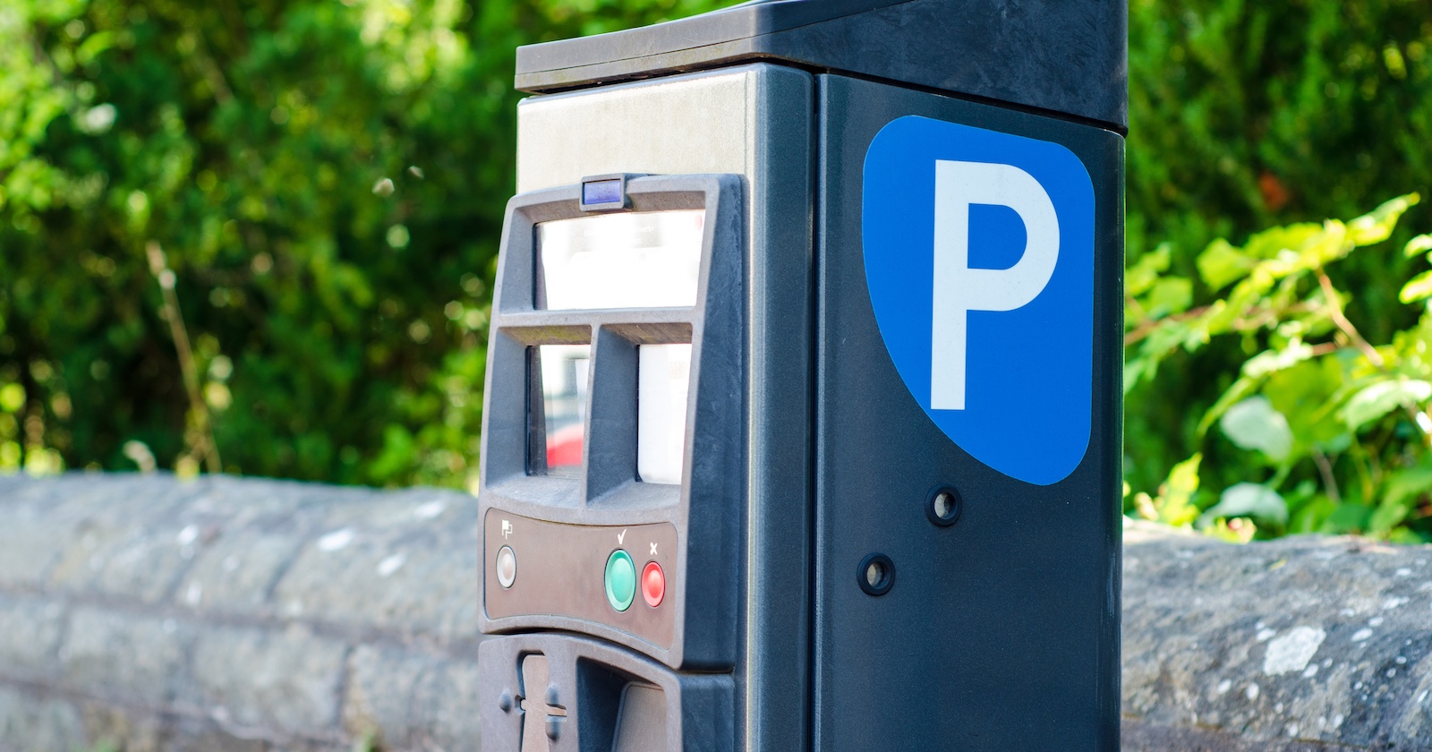 Ein Parkautomat an einem Parkplatz.