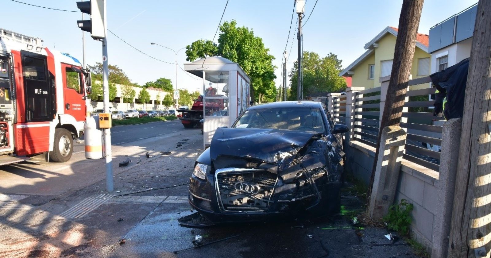 Komplett zerstörtes Auto am Gehsteig neben Haltestelle