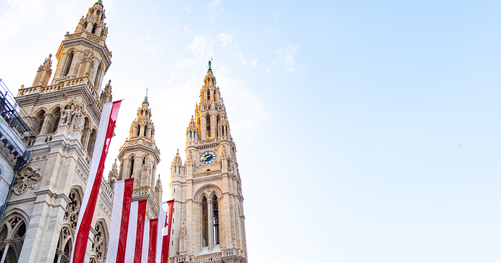 beflaggtes Wiener Rathaus vor blauem Himmel