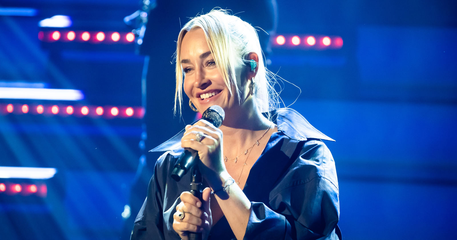 Blonde Frau singt in ein Mikrofon