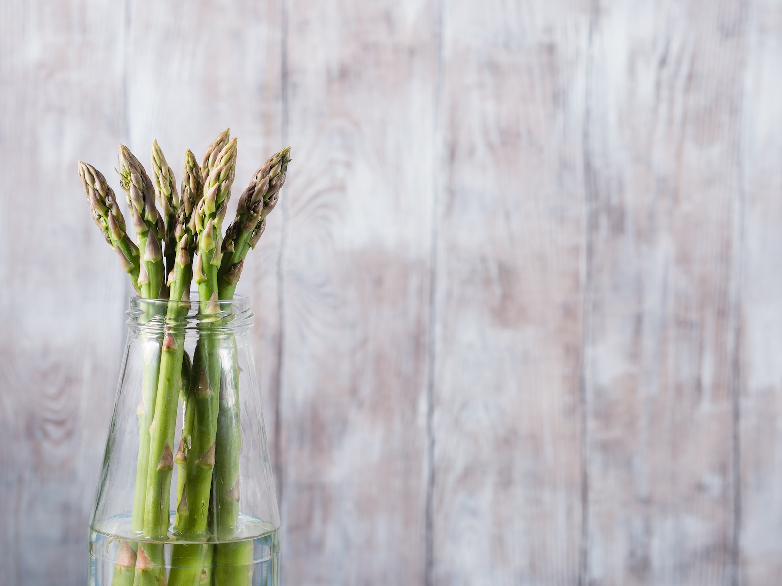 Grüner Spargel im Wasserglas.