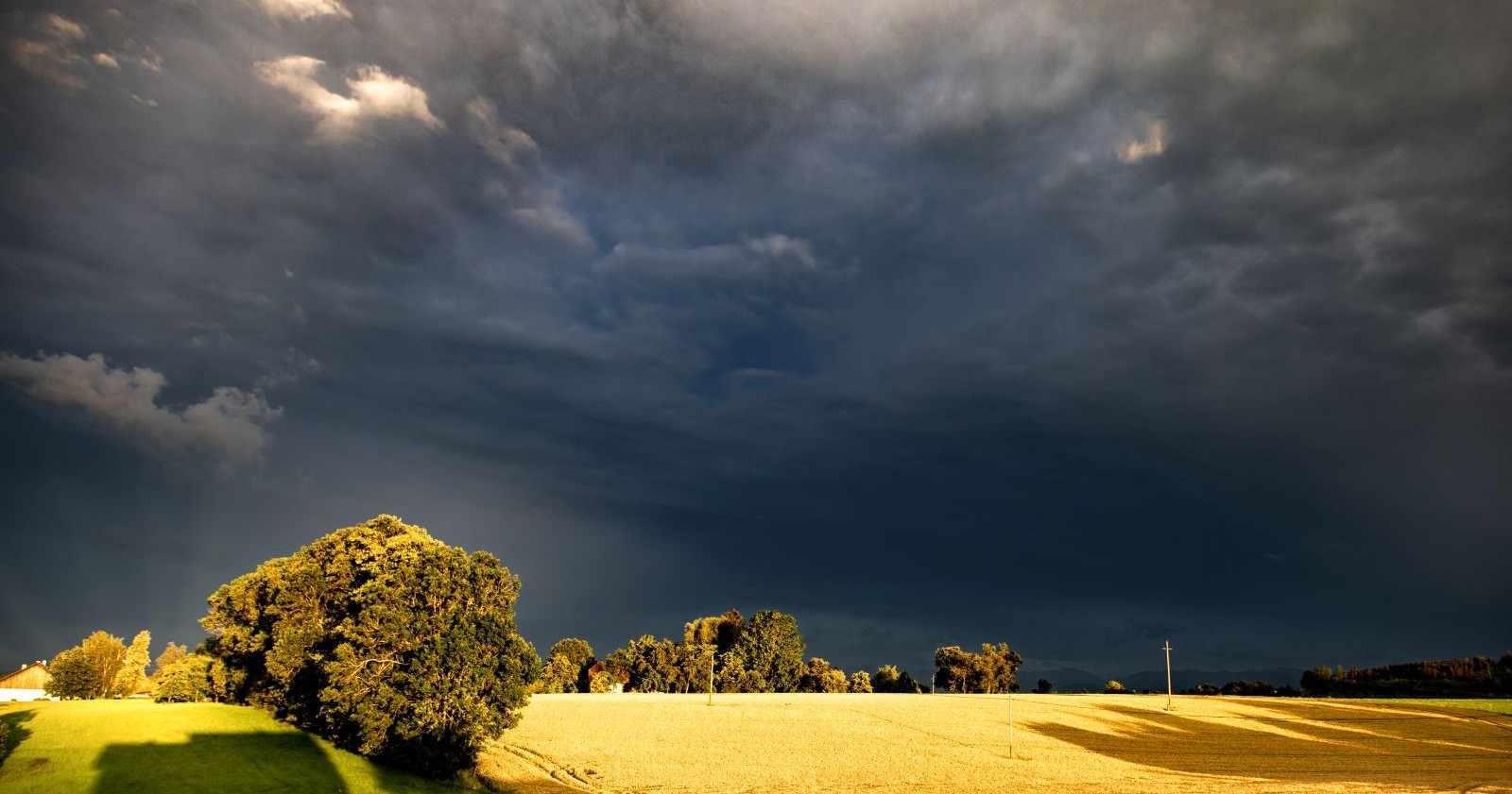 Unwetter über einem Feld bei Sonnenuntergang