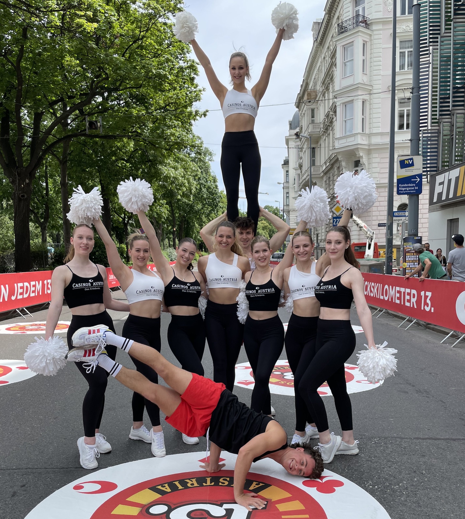 eine Gruppe Chearleader mit weißen Pompons auf einer Straße in Wien