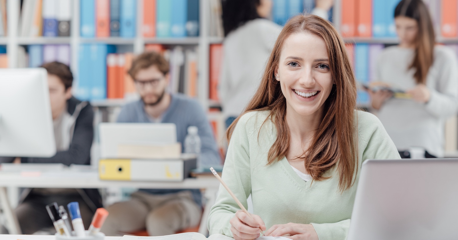 junge Frau in Klassenzimmer mit Laptop