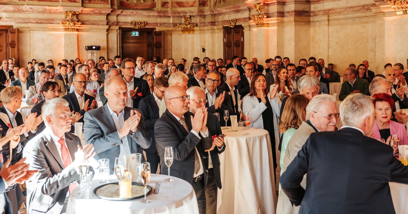Viele Gästen klatschen an Stehtischen im Palais Niederösterreich
